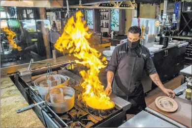  ?? L.E. Baskow Las Vegas Review-journal @Left_eye_images ?? Market Grille Cafe chef Joe Pierro Jr. prepares a flaming saganaki appetizer Wednesday at the restaurant.