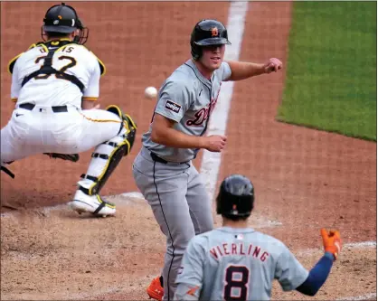  ?? PHOTOS BY GENE J. PUSKAR — THE ASSOCIATED PRESS ?? Detroit Tigers’ Kerry Carpenter, center, scores on a single by Jake Rogers off Pittsburgh Pirates relief pitcher David Bednar during the ninth inning on Tuesday. The Tigers won 5-3.