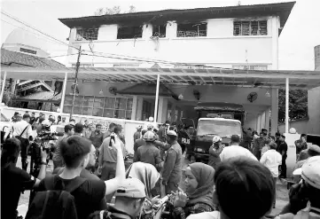  ??  ?? Fire and Rescue personnel and other govt agencies gather outside the Darul Quran Ittifaqiya­h religious school. — AFP photo