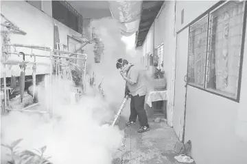  ??  ?? A city worker fumigates the area to control the spread of mosquitoes at a university in Bangkok, Thailand. — Reuters photo