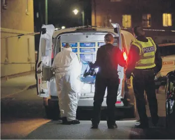  ??  ?? Police and forensics officers at the scene of the stabbing