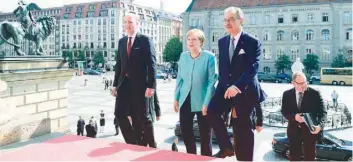  ?? — AFP ?? German Chancellor Angela Merkel and the President of the Federation of German Industry (BDI) Dieter Kempf (R) arrive for a two-day meeting of the Federation of German Industry (BDI) on Tuesday in Berlin.