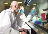  ??  ?? Mark Kidd, left, clinical laboratory and scientific director of the Branford-based Wren Laboratori­es, with clinical lab technician Rebecca Shvartsman as they examine an at-home COVID test.