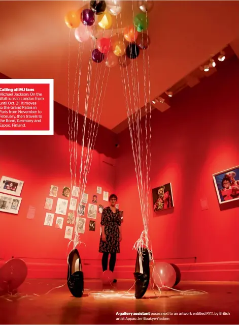  ??  ?? A gallery assistant poses next to an artwork entitled P.Y.T. by British artist Appau Jnr Boakye-Yiadom