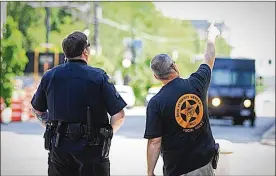  ?? MARSHALL GORBY / STAFF ?? Security experts check out the area in downtown Dayton where a Ku Klux Klanassoci­ated group from Indiana plans to hold a rally Saturday. “We’ve done our homework,” Dayton police chief Richard Biehl said.