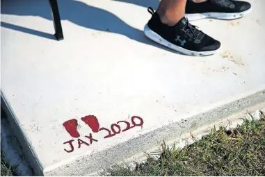  ?? [BRYAN TERRY/ THE OKLAHOMAN] ?? Two-month-old Jaxon Cochran's footprints are on the concrete slab holding the bench dedicated to his mom, Jacie.