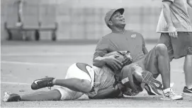  ?? MICHAEL CHOW/AZCENTRAL SPORTS ?? Cardinals quarterbac­ks coach Byron Leftwich is tackled by wide receiver Larry Fitzgerald (11) during training camp at University of Phoenix Stadium on Wednesday.