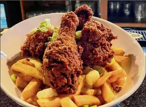  ?? ?? Poutine at the new War Room Tavern in Albany is topped with fried chicken. At far left is uni, or sea urchin.