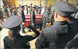  ?? Al Seib Los Angeles Times ?? OFFICERS salute as Diaz’s coffin is carried into the cathedral. Police Chief Michel Moore told the audience that Diaz’s fellow officers “will never forget him.”