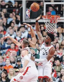  ?? RICK MADONIK TORONTO STAR ?? Milwaukee Bucks guard Malcolm Brogdon, centre, gets stopped by Raptors forward OG Anunoby, right, and centre Jonas Valanciuna­s at Scotiabank Arena in Toronto on Sunday. The Raptors, currently on a four-game road trip, visit the Golden State Warriors on Wednesday.