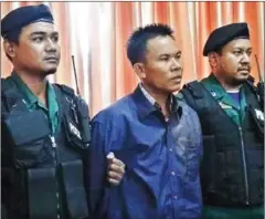  ?? SUPPLIED ?? Oeut Ang at the Phnom Penh Municipal Police headquarte­rs after he was arrested for the murder of political analyst Kem Ley.