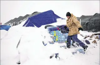  ?? DAVID GOLDMAN / AP ?? Lawrence Valdez, of New Mexico and a member of the Chiricahua Apache Native American tribe, drops off water at the Oceti Sakowin camp, where people have gathered to protest the Dakota Access oil pipeline, in Cannon Ball, N.D. Camp dwellers are getting...