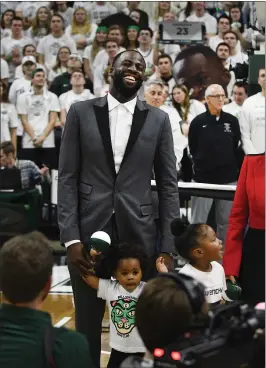  ?? DANIEL MEARS — THE DETROIT NEWS ?? Golden State Warriors’ Draymond Green and his family look to the rafters as his Michigan State jersey is hung after being retired at Breslin Center in East Lansing, Michigan.