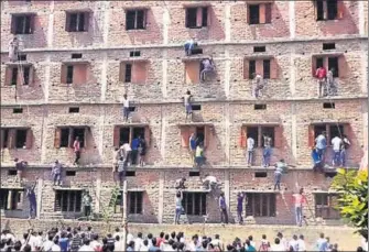  ?? AFP FILE ?? In this widely circulated picture from Uttar Pradesh’s neighbouri­ng Bihar, people climbed the walls of a school to help students cheat in an exam. The image became symbolic of the cheating menace that plagues large parts of the country.