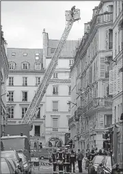  ?? AP/CHRISTOPHE ENA ?? Firefighte­rs on Sunday examine the scene of a Saturday explosion in Paris.