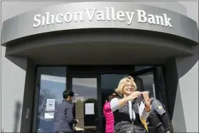  ?? BENJAMIN FANJOY — THE ASSOCIATED PRESS ?? A woman who was part of a line entering the Silicon Valley Bank’s headquarte­rs pauses for a selfie in Santa Clara, Calif., on Monday.