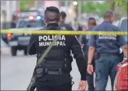  ??  ?? Un policía municipal resguarda la zona donde ocurrió un hecho violento en Cancún. Ayer, autoridade­s de Tulum reportaron el hallazgo de los cuerpos de una familia en un condominio de un complejo turístico
