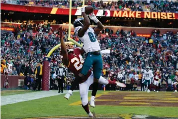  ?? AP Photo/Alex Brandon ?? ■ Philadelph­ia Eagles wide receiver Greg Ward (84) catches a touchdown pass, beating out Washington Redskins cornerback Josh Norman (24), in the second half Sunday in Landover, Md. The Eagles won, 37-27.
