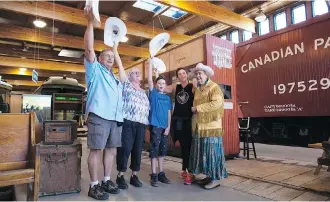  ?? GAVIN YOUNG ?? From left, Pierre, Katherine, Liam and Natalie Dubreuil, winners of Heritage Park’s Journey of a Lifetime contest, are white-hatted by Tourism Calgary volunteer Elaine Baumann at the park on Monday.