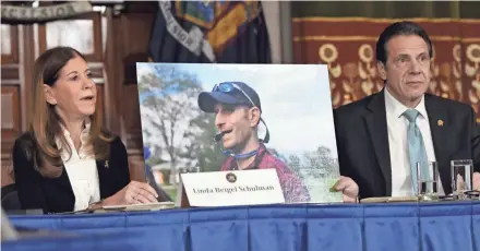  ?? HANS PENNINK/AP ?? Linda Beigel Schulman shows a photo of her son Scott Beigel, a teacher slain in last year’s school shooting in Parkland, Florida, to gun safety advocates and New York Gov. Andrew Cuomo (right).
