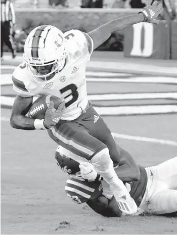  ?? CHRIS SEWARD /AP ?? Miami wide receiver Mike Harley fights for more yardage as he is hit by Duke cornerback Leonard Johnson after making a reception during the second half Saturday in Durham, N.C.