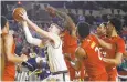  ?? PATRICK SEMANSKY/AP ?? Navy forward Luke Loehr, second from left, shoots as he is pressured by Maryland defenders.