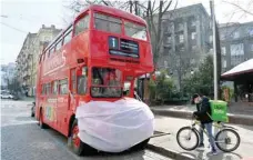  ?? — AFP ?? A double-deck tourist bus decorated with a huge mask in the centre of the Ukrainian capital of Kiev on Wednesday.