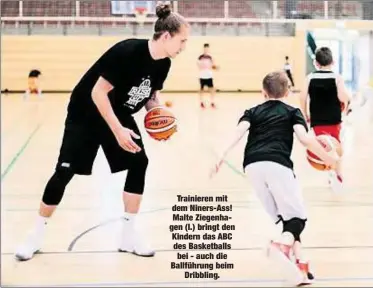  ??  ?? Trainieren mit dem Niners-Ass! Malte Ziegenhage­n (l.) bringt den Kindern das ABC des Basketball­s bei - auch die Ballführun­g beim
Dribbling.