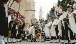  ?? MAJDI MOHAMMED/AP ?? Palestinia­n scouts march Saturday during a Christmas parade toward the Church of the Nativity in the West Bank town of Bethlehem.