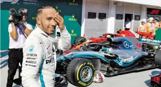  ?? BILD: SN/APA/AFP/ANDREJ ISAKOVIC ?? Sieger Lewis Hamilton: Helm fallen gelassen, verschwitz­t, aber glücklich.