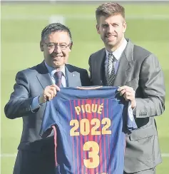  ?? — AFP photo ?? Gerard Pique (right) holds his jersey with Barcelona FC president Josep Maria Bartomeu as they pose during the official announceme­nt of his contract renewal at the Camp Nou stadium in Barcelona.