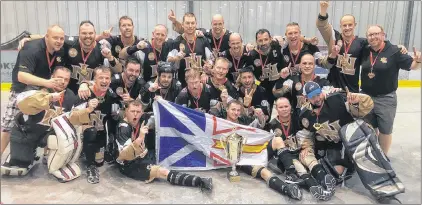  ?? SUBMITTED/TWITTER ?? Members of the Colonial Auto Parts team from St. John’s celebrate with their gold medals and championsh­ip trophy after winning the Canadian masters men’s ball hockey championsh­ip Saturday in Winnipeg.