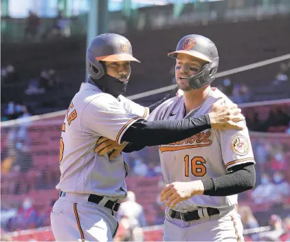  ?? STEVEN SENNE/AP ?? The Orioles’ Anthony Santander, left, and Trey Mancini celebrate after scoring on a double by Maikel Franco in the first inning against the Red Sox on Sunday in Boston.