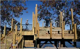  ?? (Arkansas Democrat-Gazette/Stephen Swofford) ?? Mark Trammel (left) and Jesse Lawson work on a treehouse being built on the bank of the Arkansas River Tuesday in Little Rock’s Riverfront Park.