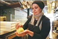  ?? LORIN ELENI GILL / AP ?? Muna Anaee prepares a ball of khobz orouk, a flatbread she would eat frequently in her native Iraq, in San Francisco during the inaugural Refugee Food Festival, on June 20.