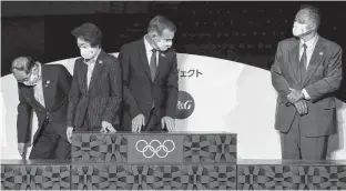  ?? REUTERS ?? Officials including Seiko Hashimoto (second from left), president of the Tokyo 2020 Organizing Committee; Stanislav Vecera (third from left), CEO and president of Procter & Gamble Japan; and Japanese Olympic Committee President Yasuhiro Yamashita (right) prepare for a photo session next to a podium during an unveiling event of the items that will be used for the victory ceremonies of the Tokyo 2020 Olympic and Paralympic Games, at Ariake Arena in Tokyo, Japan on Thursday.
