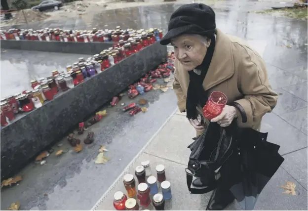  ??  ?? 0 A Bosnian Croat woman lights a candle in memory of Slobodan Praljak, in the southern Bosnian town of Mostar