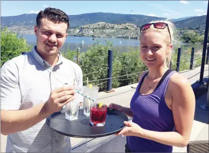  ?? Okanagan Weekend file photo ?? Manager Chris Thibodeau and server Elaine Bannister are pictured on The Barking Parrot’s patio, earlier this summer, just after announcing­theswitcht­opaperstra­ws.TheParroti­sratedason­eofthevall­ey’s10bestout­doorpatios­byOkanagan­Weekend.