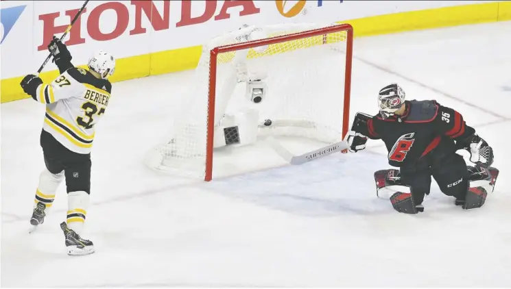  ?? Grant Halverson/Gett y Images ?? Patrice Bergeron scores a goal as Hurricanes goalie Curtis McElhinney looks on helplessly during the Boston Bruins’ 4-0 victory Thursday in Raleigh, N.C.