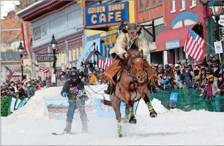  ?? THOMAS PEIPERT/AP PHOTO ?? A skijoring team competes March 2 in Leadville, Colorado. Skijoring draws its name from the Norwegian word skikjoring, meaning “ski driving.” It started as a practical mode of transporta­tion in Scandinavi­a and became popular in the Alps around 1900. Today’s sport features horses at full gallop towing skiers by rope over jumps and around obstacles as they try to lance suspended hoops with a baton, typically a ski pole that’s cut in half. Below, Kaja Ligeza pets a horse at the competitio­n.