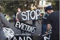  ??  ?? Housing activists erect a sign in front of Massachuse­tts Gov. Charlie Baker’s house in Swampscott, Mass., in October. A moratorium put in place by the Centers for Disease Control in September that protects certain renters from eviction expires at the end of the year.
