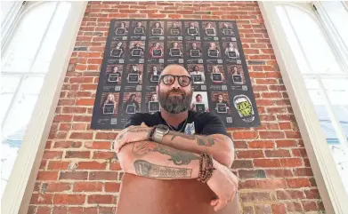  ?? MICHAEL CLEVENGER/ COURIER JOURNAL ?? Phil Stucky is the head of Thrive, a substance abuse recovery organizati­on. The faces on the wall behind him are allies of Thrive and those who are open about their recovery.