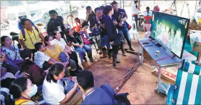  ?? SAKCHAI LALIT / ASSOCIATED PRESS ?? Above: Families watch a video clip of the boys on TV after they were found alive.