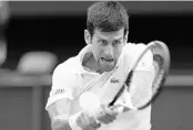  ?? NIC BOTHMA/ASSOCIATED PRESS ?? Novak Djokovic of Serbia returns a ball to Rafael Nadal of Spain during Saturday’s men’s singles semifinal match.