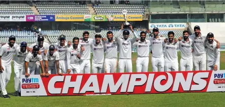  ?? — AP ?? Members of the Indian team pose with the winners trophy after beating New Zealand on Day Four of the second Test in Mumbai on Monday. India won the match by 372 runs to take the series 1-0.