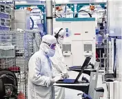  ?? CONTRIBUTE­D ?? Employees wearing clean room “bunny suits” work at Intel’s D1X factory in Hillsboro, Oregon.