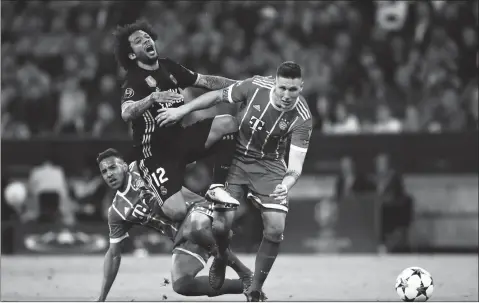  ?? Photo: VCG ?? Real Madrid fullback Marcelo (center) battles for the ball with Niklas Sule (left) and Corentin Tolisso of Bayern Munich during their Champions League semifinal first-leg match on Wednesday in Munich, Germany.