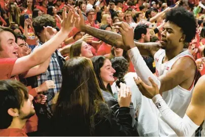  ?? JULIA NIKHINSON/AP ?? Maryland guard Hakim Hart high-fives fans after the Terps beat Northweste­rn, 75-59, on Sunday in College Park.