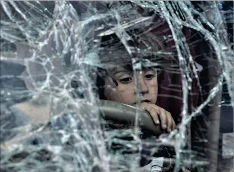  ?? Picture: Chris Mcgrath ?? A boy looks out through the smashed windscreen of his family’s car after arriving in Zaporizhzh­ia, Ukraine, after fleeing Mariupol