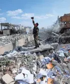  ?? HASSAN AMMAR/AP ?? A Syrian soldier films the damage of the Syrian Scientific Research Center, which was attacked by coalition airstrikes.